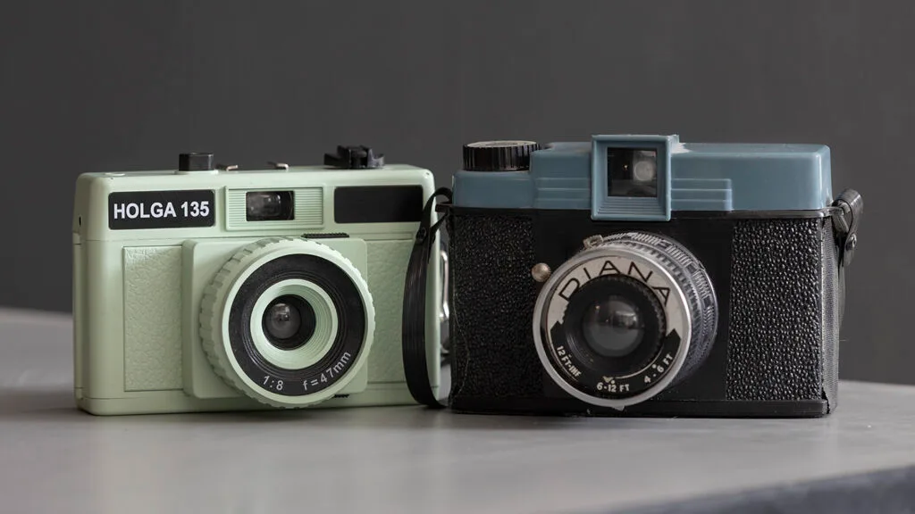 View of a 35mm Holga camera on the left and a Diana 120 camera on the right.